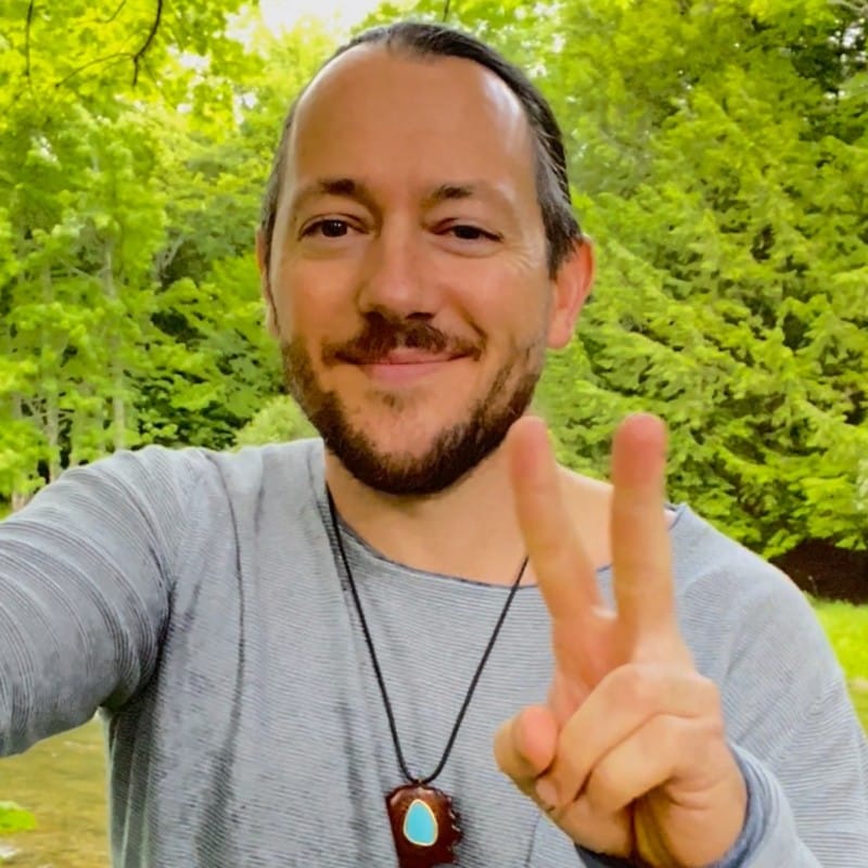 smiling man throwing a peace sign